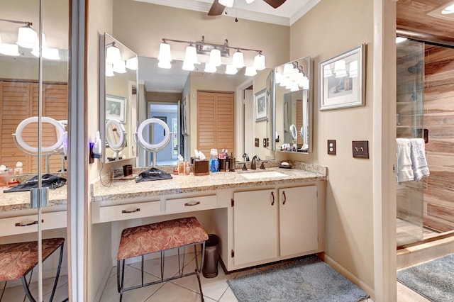 bathroom with tile patterned flooring, crown molding, walk in shower, and vanity