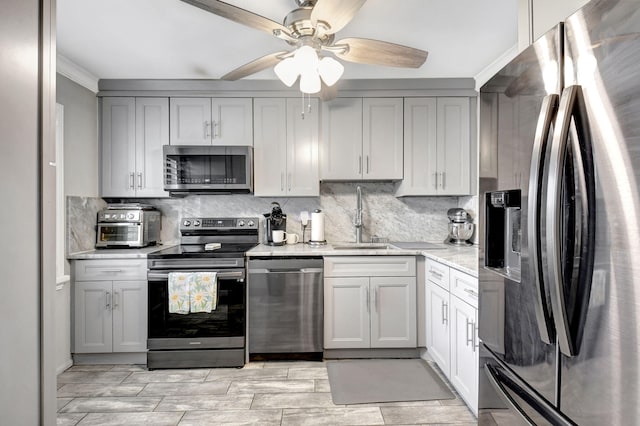 kitchen with sink, backsplash, gray cabinets, and stainless steel appliances