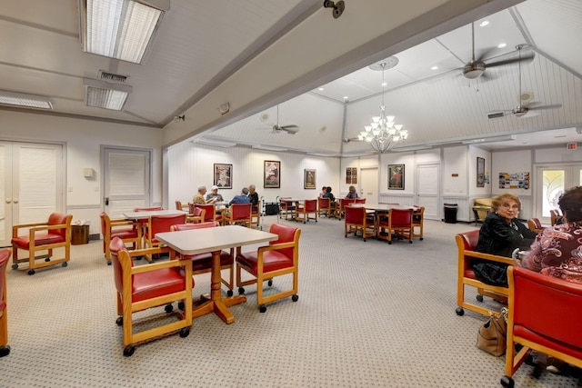 dining room featuring light colored carpet, vaulted ceiling, and ceiling fan with notable chandelier