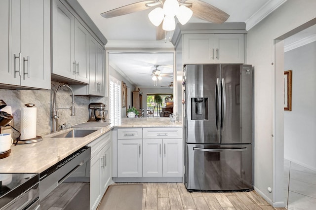 kitchen featuring decorative backsplash, sink, black dishwasher, ornamental molding, and stainless steel fridge