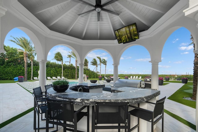 view of patio with a bar, area for grilling, grilling area, and ceiling fan