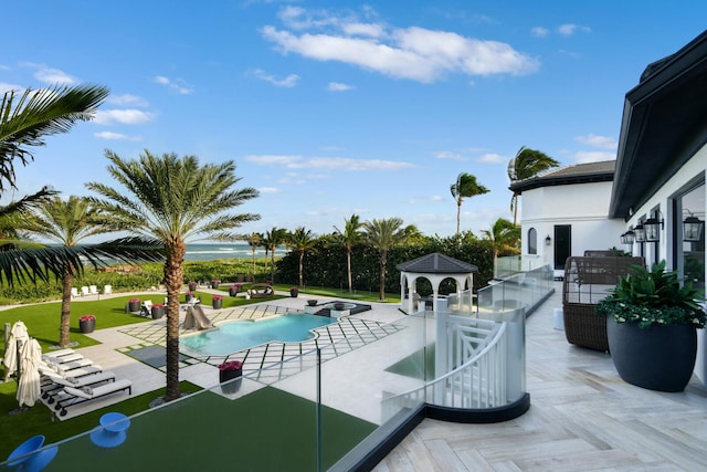 view of swimming pool with a gazebo, a water view, an outdoor living space, a patio area, and an in ground hot tub