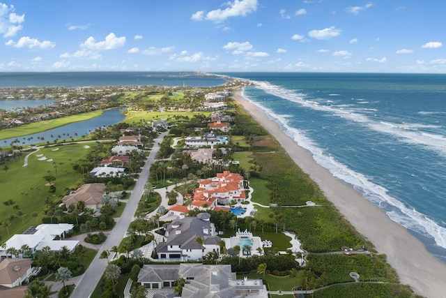 birds eye view of property with a water view and a beach view