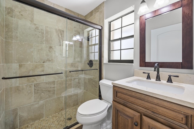 bathroom featuring walk in shower, vanity, and toilet