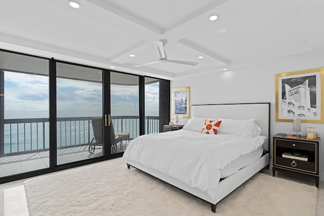 bedroom with beamed ceiling, access to outside, expansive windows, a water view, and ceiling fan