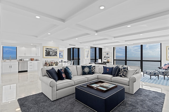 tiled living room with coffered ceiling, sink, a water view, and beam ceiling