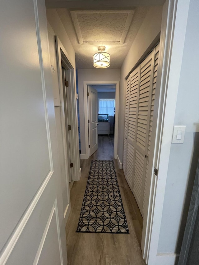 hallway featuring a textured ceiling and light hardwood / wood-style floors