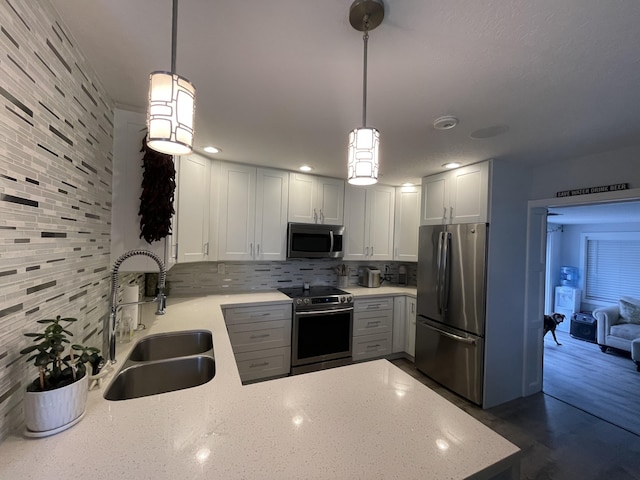 kitchen with stainless steel appliances, tasteful backsplash, decorative light fixtures, and sink