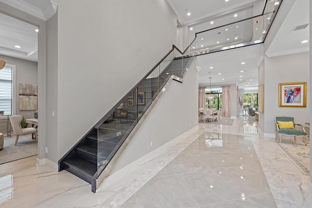 staircase with a high ceiling, crown molding, and light tile patterned floors