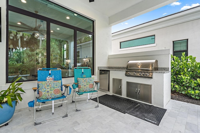 view of patio featuring an outdoor kitchen and a grill