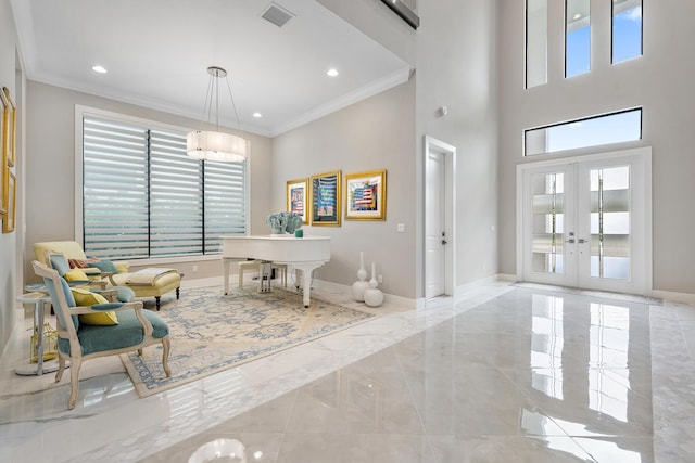 interior space featuring a wealth of natural light, french doors, a towering ceiling, and crown molding