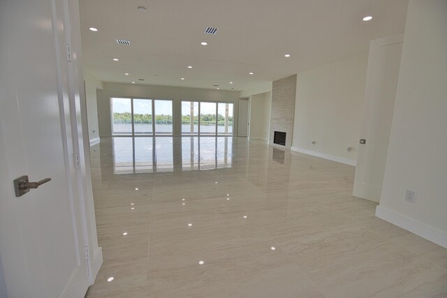 13064 Via Flavia, Placida, FL 33946 - unfurnished room with a water view, baseboards, recessed lighting, a fireplace, and marble finish floors