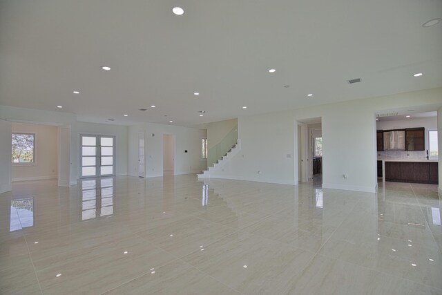 13064 Via Flavia, Placida, FL 33946 - unfurnished living room with baseboards, light tile patterned floors, stairway, french doors, and recessed lighting