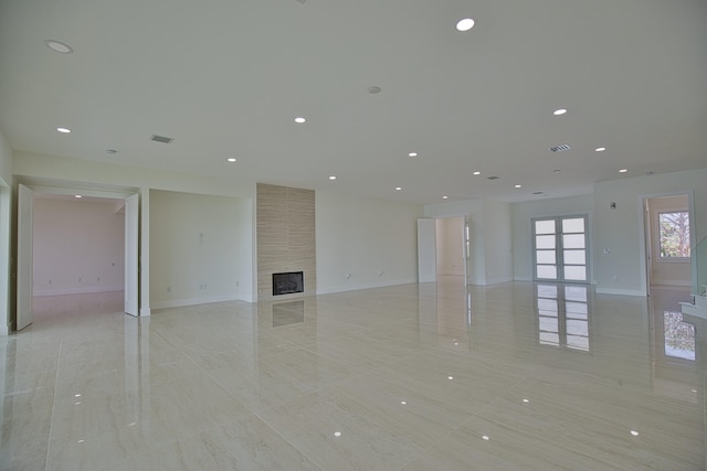 unfurnished living room featuring a large fireplace and light tile patterned floors