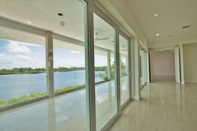 interior space with a water view and light tile patterned floors