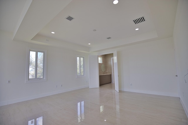 tiled empty room with a tray ceiling