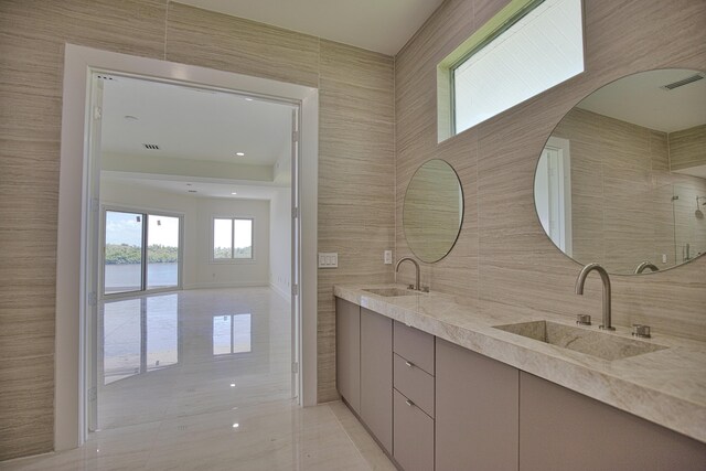 13064 Via Flavia, Placida, FL 33946 - bathroom featuring tile walls, double vanity, and a water view