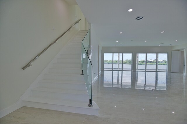 13064 Via Flavia, Placida, FL 33946 - staircase featuring a water view, recessed lighting, and baseboards