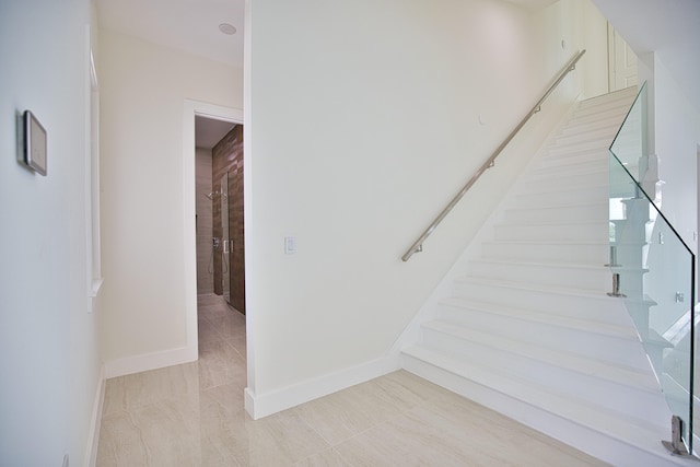 staircase featuring light tile patterned flooring