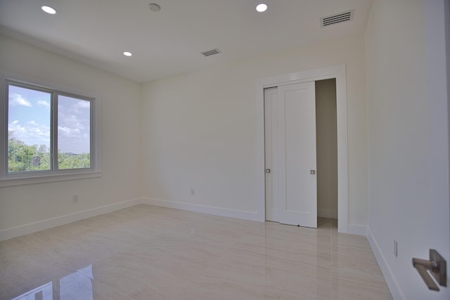 unfurnished bedroom featuring light tile patterned flooring and a closet