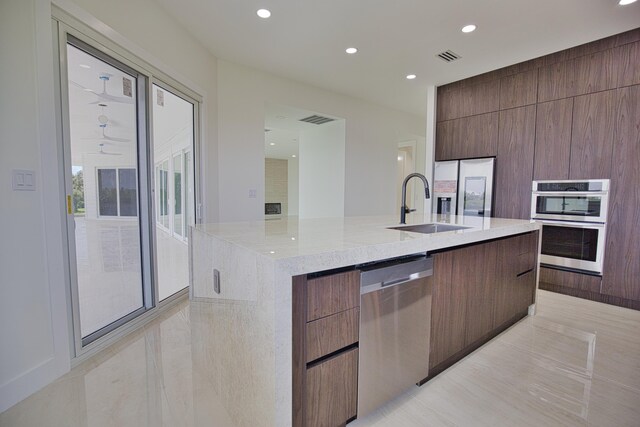 13064 Via Flavia, Placida, FL 33946 - kitchen featuring appliances with stainless steel finishes, modern cabinets, a sink, an island with sink, and recessed lighting