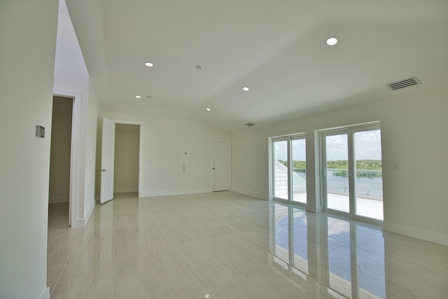 tiled spare room with lofted ceiling