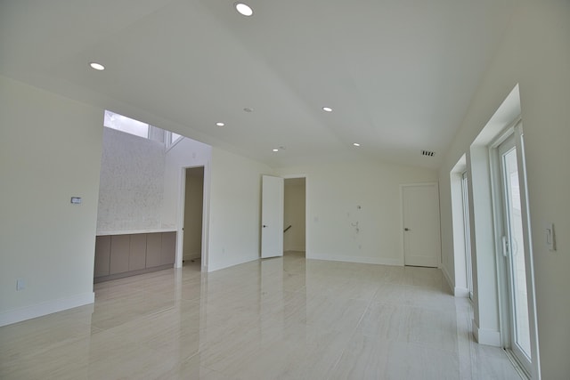 unfurnished room featuring vaulted ceiling and light tile patterned floors