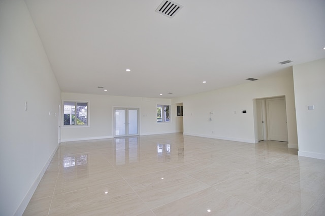 tiled empty room featuring french doors