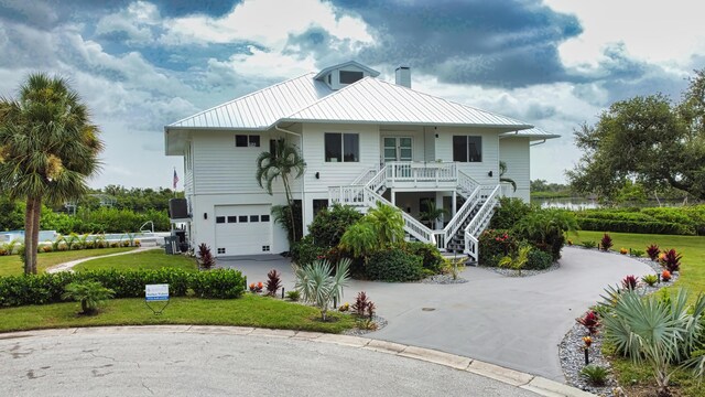 13064 Via Flavia, Placida, FL 33946 - view of front of property with stairway, a standing seam roof, covered porch, an attached garage, and driveway