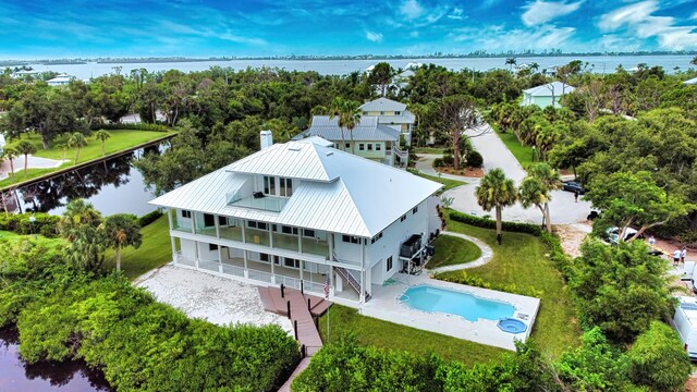 13064 Via Flavia, Placida, FL 33946 - back of property featuring a water view, metal roof, a patio area, and an outdoor pool