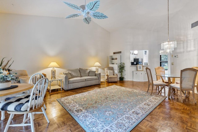 living room with parquet floors, high vaulted ceiling, and ceiling fan with notable chandelier