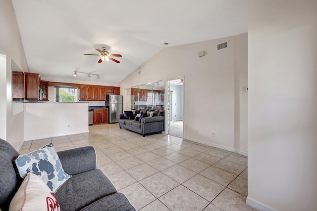 living room featuring vaulted ceiling, ceiling fan, and light tile patterned floors