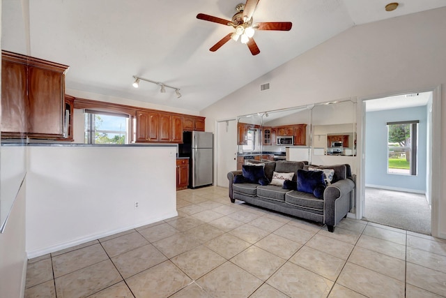 living room with lofted ceiling, ceiling fan, and light tile patterned flooring