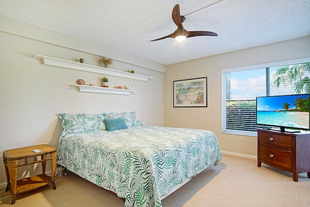 carpeted bedroom with ceiling fan and a textured ceiling