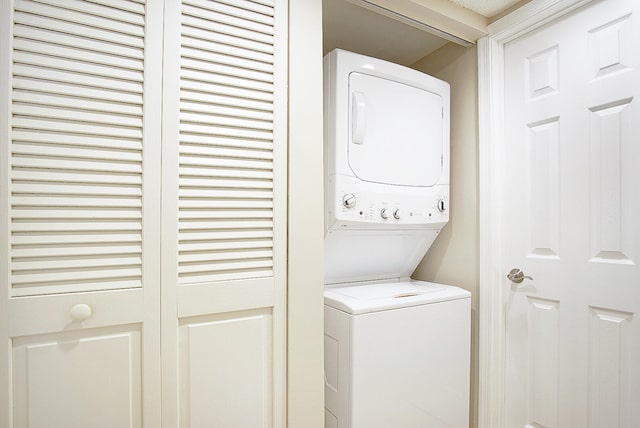 laundry area featuring stacked washer / drying machine