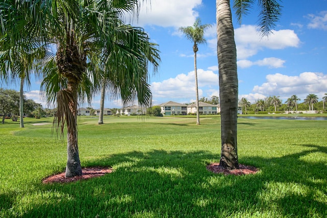 surrounding community featuring a water view and a lawn