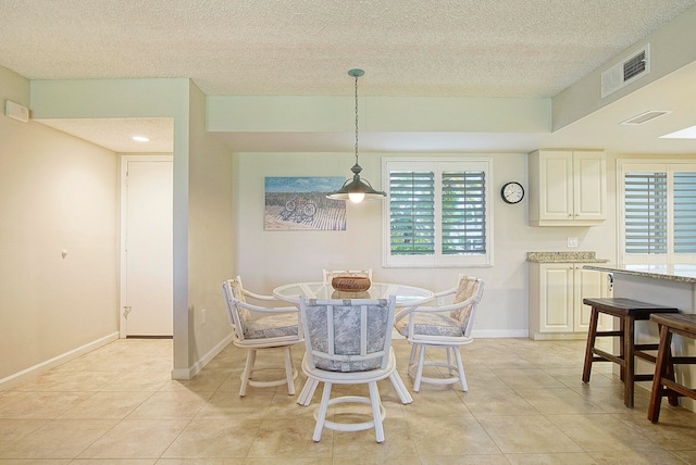 tiled dining area featuring a textured ceiling