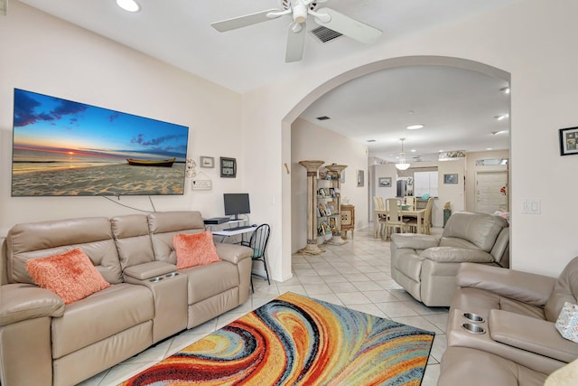 living room with visible vents, light tile patterned floors, recessed lighting, arched walkways, and a ceiling fan
