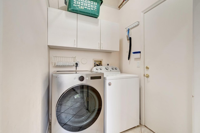 washroom with cabinet space and separate washer and dryer