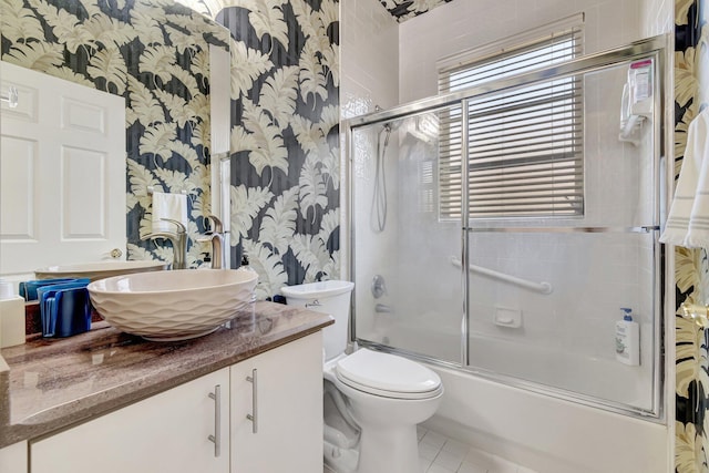 bathroom with tile patterned flooring, wallpapered walls, toilet, enclosed tub / shower combo, and vanity