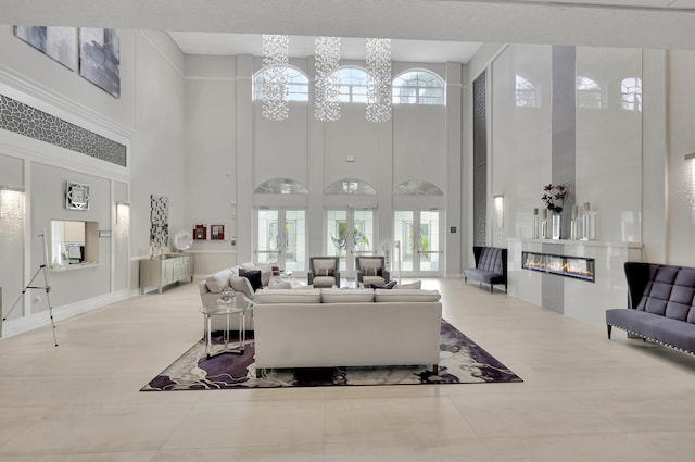 tiled living area featuring a chandelier and a glass covered fireplace