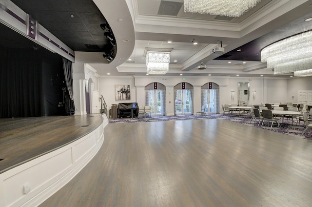 exercise room featuring a raised ceiling, recessed lighting, wood finished floors, and ornamental molding