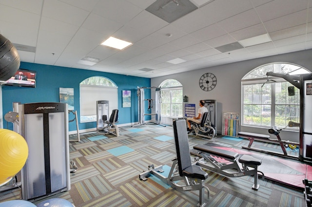 gym with a drop ceiling, visible vents, baseboards, and carpet floors