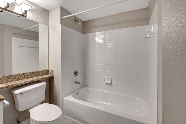 bathroom with washtub / shower combination, a textured wall, and toilet