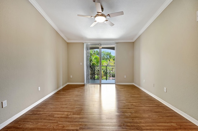 unfurnished room featuring a ceiling fan, baseboards, crown molding, and wood finished floors