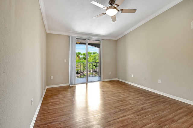 spare room with baseboards, a textured wall, ceiling fan, wood finished floors, and crown molding