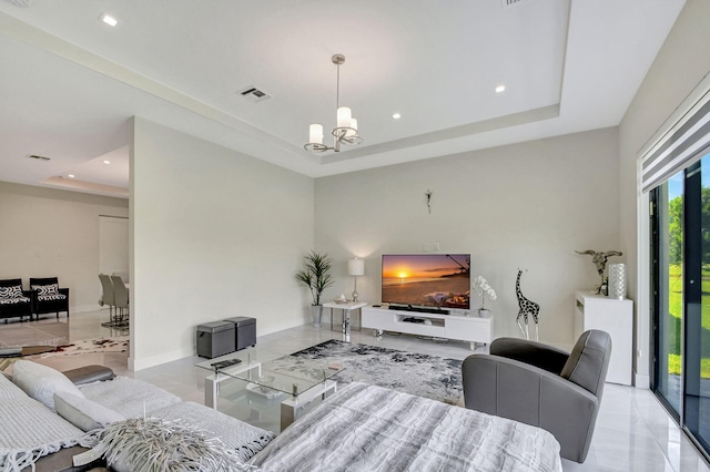 living room with a raised ceiling and a chandelier