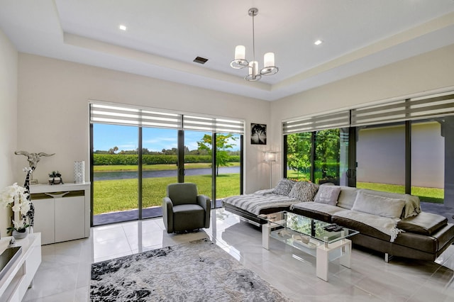 living room featuring an inviting chandelier and a raised ceiling