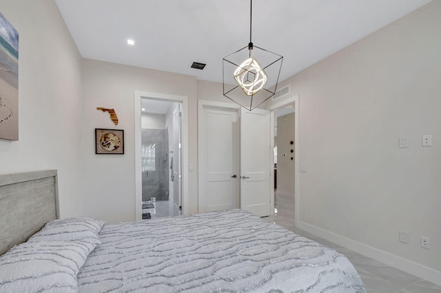 bedroom with an inviting chandelier and connected bathroom