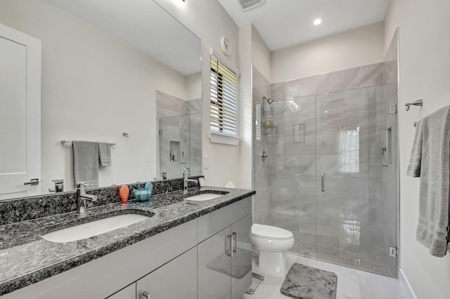 bathroom with vanity, toilet, and a shower with door